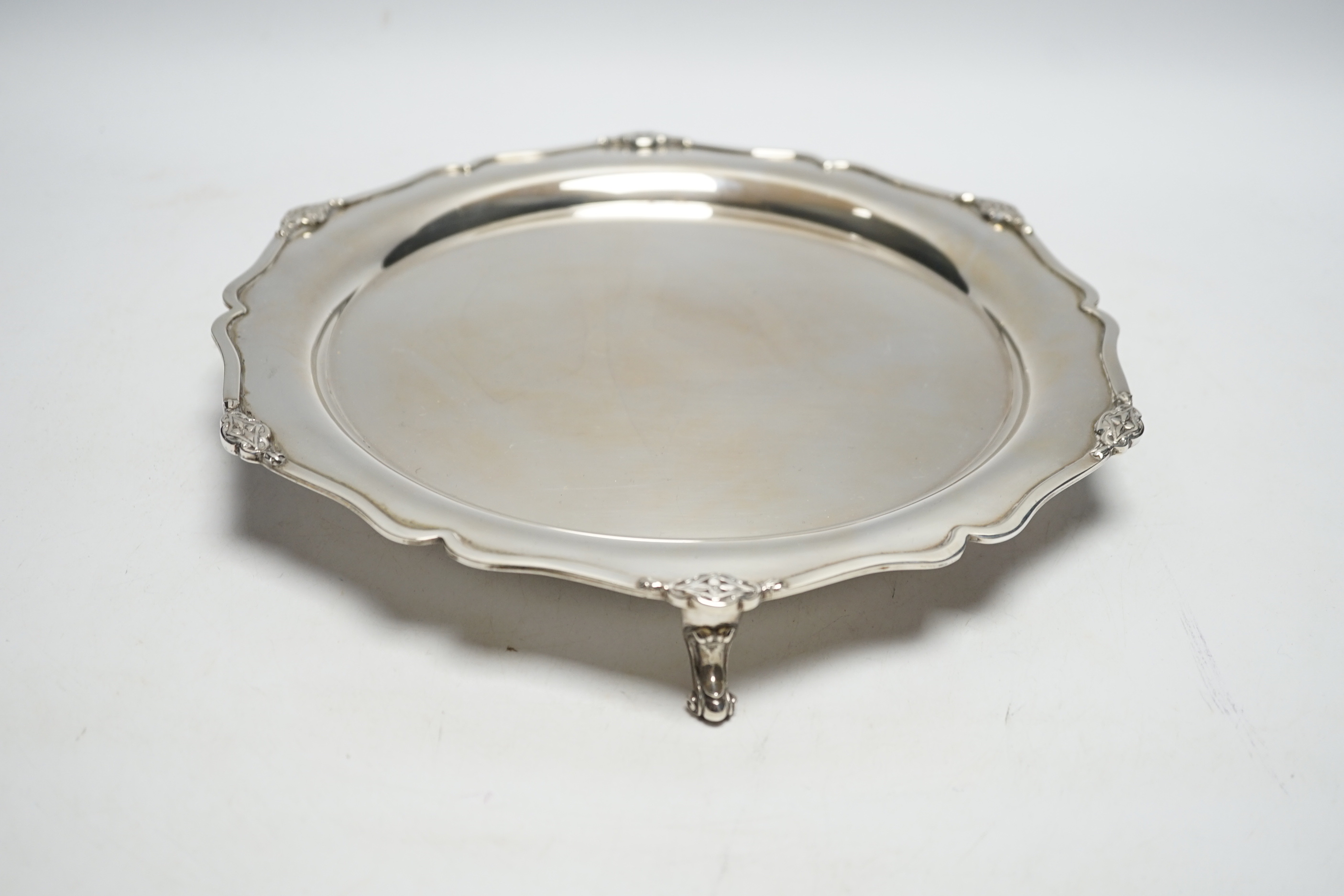 A George V silver shaped circular salver, on three scroll feet, Martin, Hall & Co, Sheffield, 1929, 26.9cm, 17.2oz.